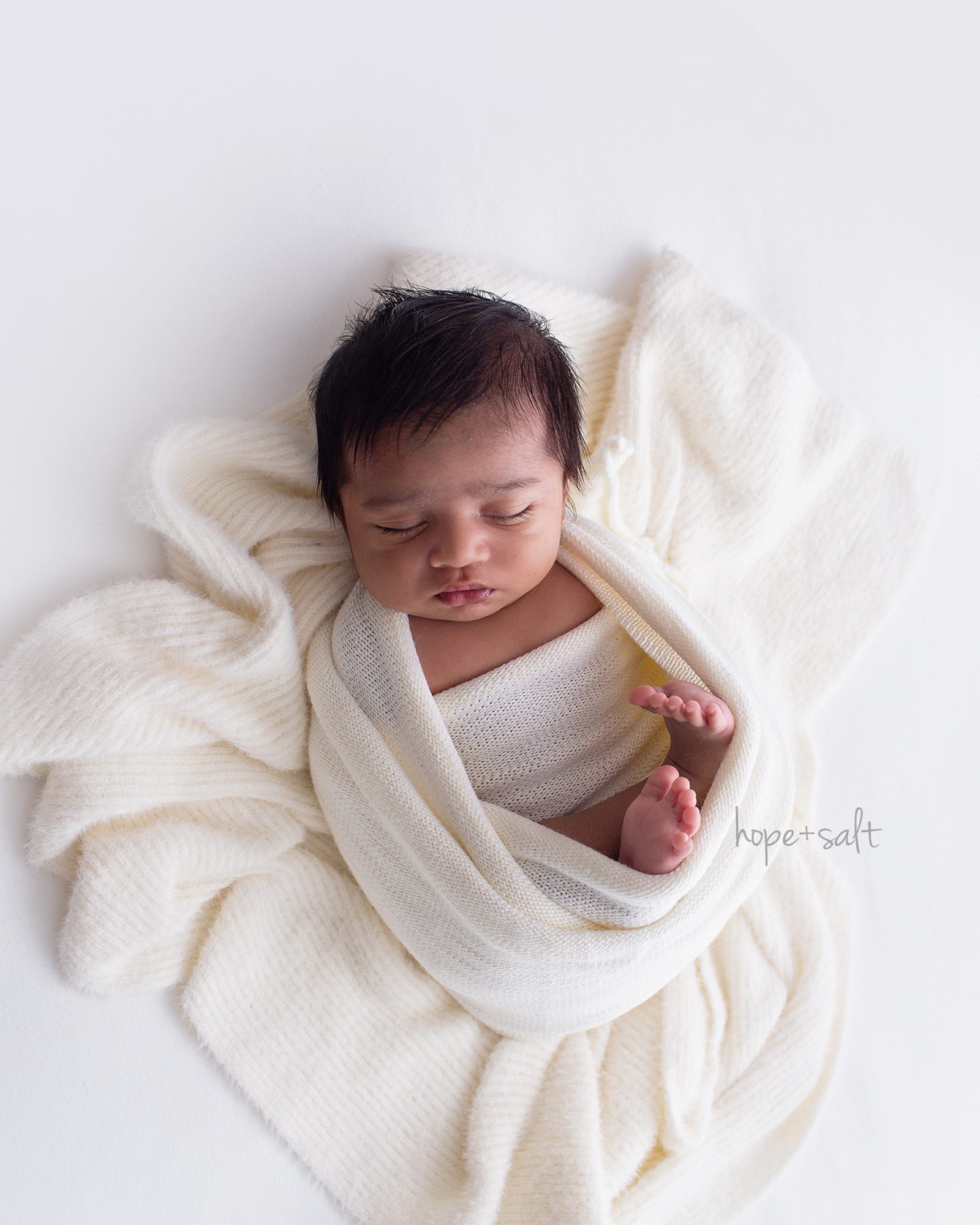 baby A studio newborn session cream fluffy wrap on top of layered ribbed blanket neutrals simple natural high end luxury session