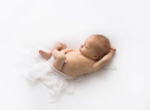 a simple and natural baby photoshoot using womb like poses for sleeping wispy blond haired boy by ancaster ontario newborn photographer Hope + Salt